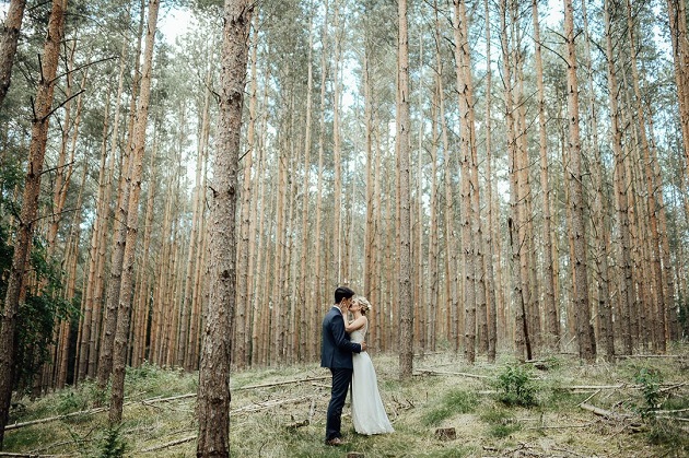 Novia y novio besándose en el bosque